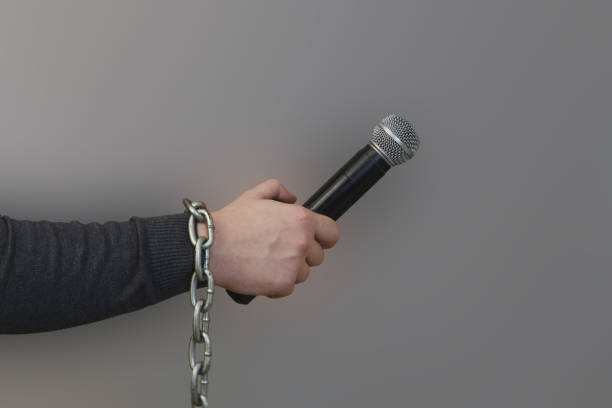 istock A journalist's hand with a chain on it holds a microphone , freedom limitation and repression concept; 2156463765
