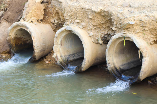 istock drainage pipe. close up Water flows through a drainage pipe to the next river 2156465715