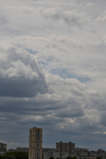 istock Big cumulus clouds over city, vertical shot 2156467335