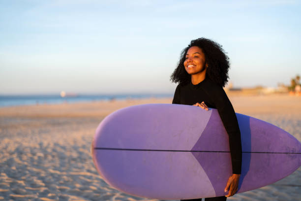 istock Joyful Black Female Surfer with Board on Beach 2156467734