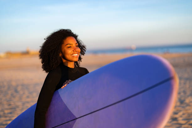 istock Joyful Black Woman with Surfboard on Beach 2156467742
