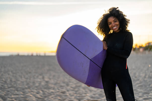 istock Joyful Black Female Athlete with Surfboard at Beach 2156467748