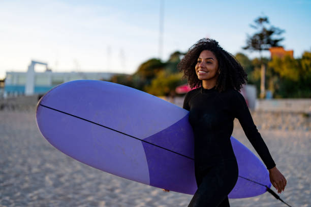 istock Joyful Black Female Surfer with Board at Beachside 2156467754