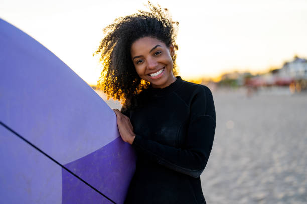 istock Joyful Black Female Surfer with Surfboard at Beach 2156467758