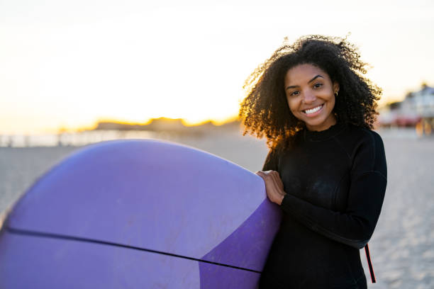 istock Joyful Black Female Surfer with Board on Beach at Sunset 2156467761