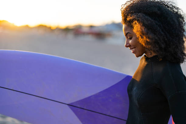 istock Joyful Black Female Surfer with Board on Beach at Sunset 2156467766
