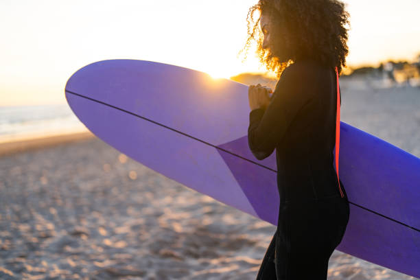 istock Joyful Black Surfer Woman with Board on Beach at Sunset 2156467779