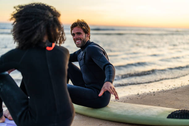 istock Interracial Couple Enjoying Sunset Beach Surf Session 2156467803