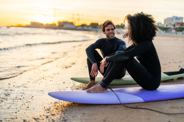 istock Diverse Couple Sharing a Moment on Surfboards at Sunset Beach 2156467815