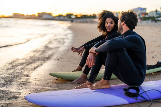 istock Diverse Couple Enjoying Sunset Surf Session 2156467818