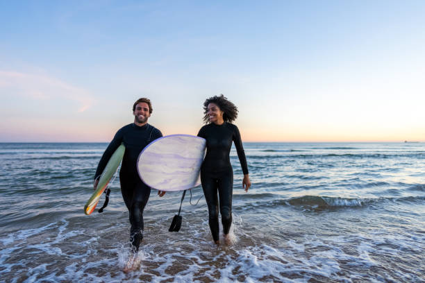 istock Diverse Couple with Surfboards at Beach Sunset 2156467838