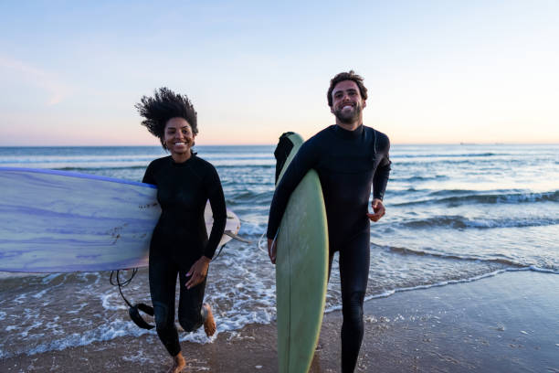 istock Joyful Diverse Couple with Surfboards on Beach 2156467854