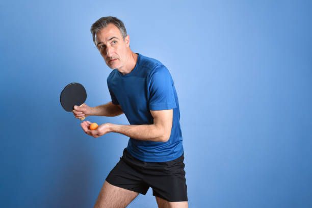 istock Ping-pong player ready to make a serve on blue background 2156469004
