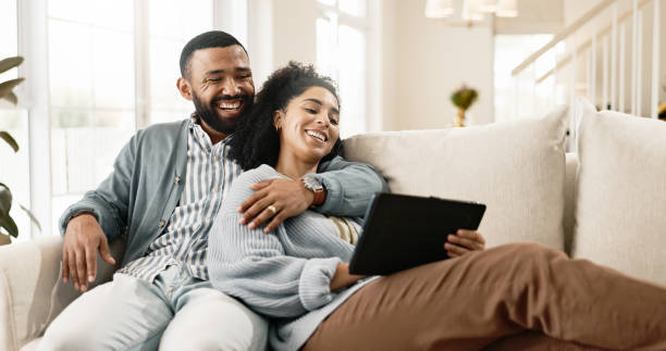 istock Couple, love and internet on sofa with tablet on streaming application for home entertainment, subscription and movies. Man, woman and together in house with technology on couch for online videos. 2156469148