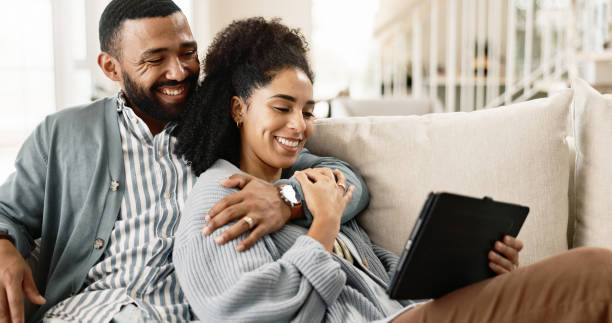 istock Couple, love and internet on couch with tablet on streaming application for home entertainment, subscription and movies. Man, woman and together in house with technology on sofa for online videos. 2156469149