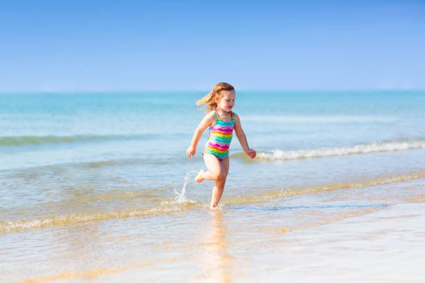 istock Kids playing on beach. Children play at sea. 2156470590
