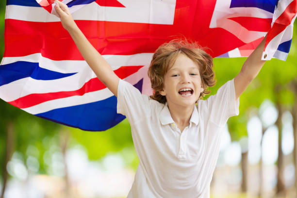 Young Indonesian boy proudly waving the red and white national flag under a bright blue sky, symbolizing patriotism, freedom, and national pride in a vibrant outdoor setting.