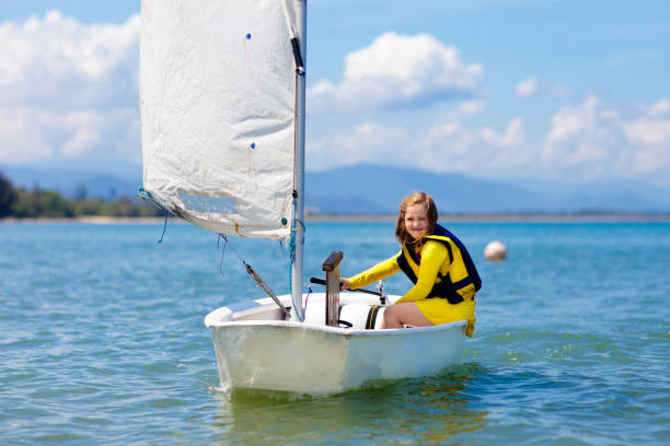 Child sailing. Kid learning to sail on sea yacht. Healthy water sport for school kids. Yachting class for young sailor. Children on boat. Family summer vacation on tropical island. Beach activity.