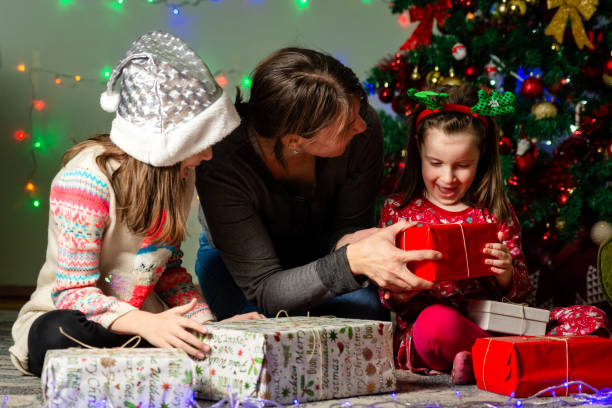 istock Mother giving Christmas presents to her daughters 2156473356