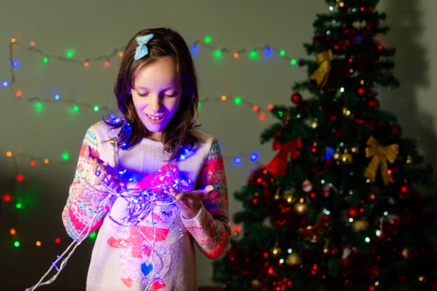 istock Girl holding Christmas lights in her hands 2156476480