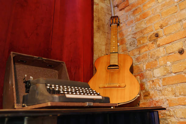 istock A guitar and a typewriter in a room with red curtains and a brick wall. 2156477886