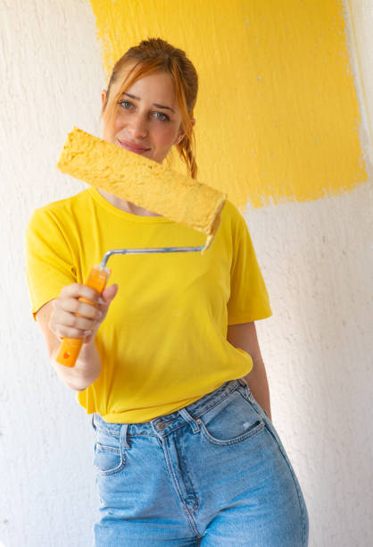 istock Young women painting a wall with paint roller 2156478001