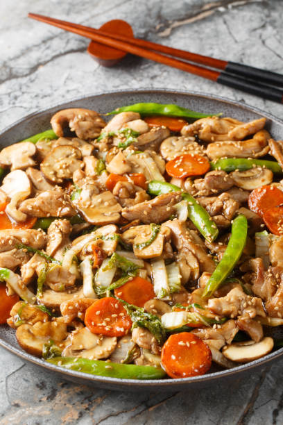 istock Moo goo gai pan Chinese American version is a simple stir-fried dish with thin sliced chicken, mushrooms and other vegetables closeup on the plate. Vertical 2156478440