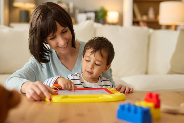 istock Mom teaching cute boy drawing on board together at home 2156480284
