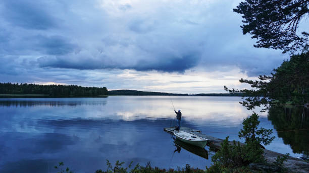 istock Blue lake with fishing men 2156480829