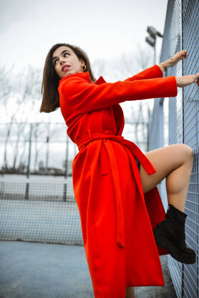 istock Female In Red Coat Pulling On Tennis Court Metal Web 2156483069
