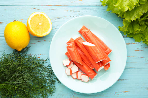 istock Cut crab sticks in bowl on blue wooden background. 2156484392