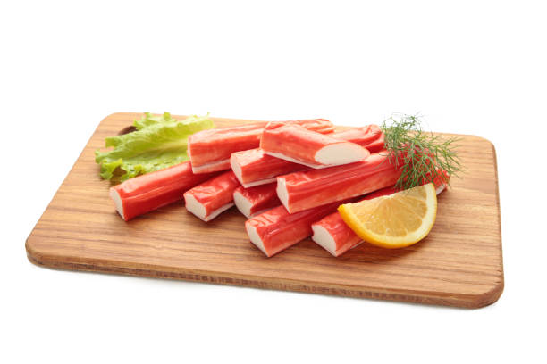 istock Fresh crab sticks with lemon on cutting board isolated on white background. 2156484442