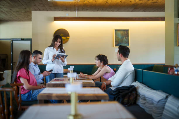 istock Waitress is taking orders with digital tablet menu from customers at the restaurant 2156484727