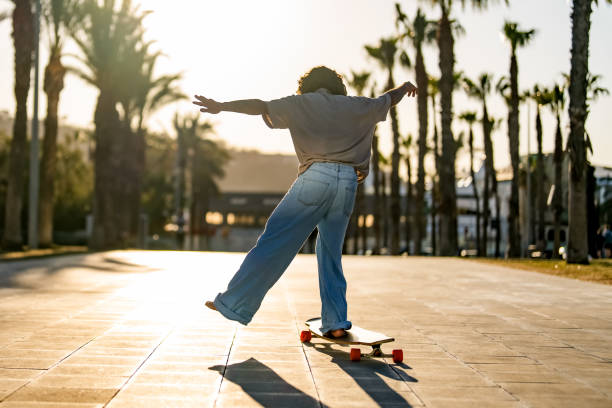 istock Hispanic Skateboarder Mastering Longboard Tricks at Sunset 2156488727