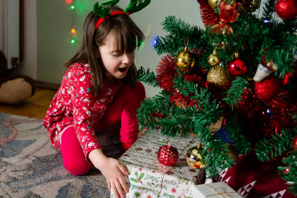 Little girl takes a present from under the Christmas tree
