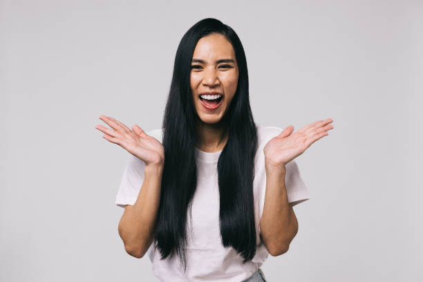 Asian woman making a joyful expression in her casual white shirt