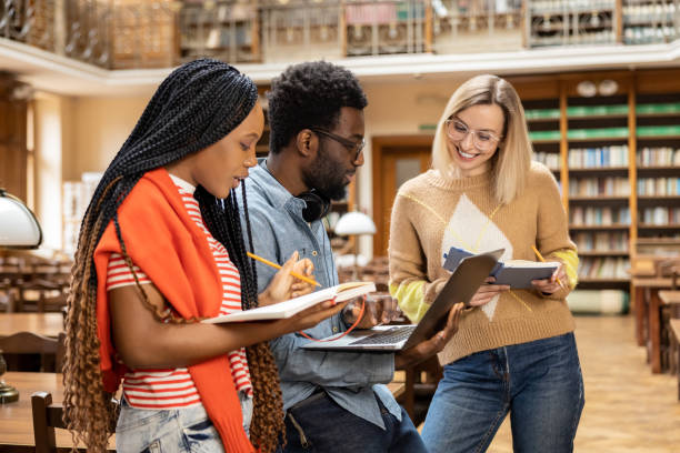 istock Group of young people in the library looking busy and intersted 2156494154