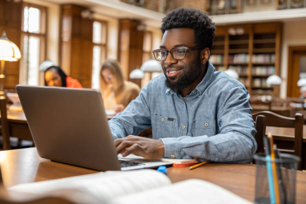 istock Dark-skinned young man working online in the library 2156494276
