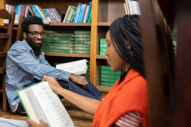istock African american students reading books while sitting on the floor in the library 2156494321