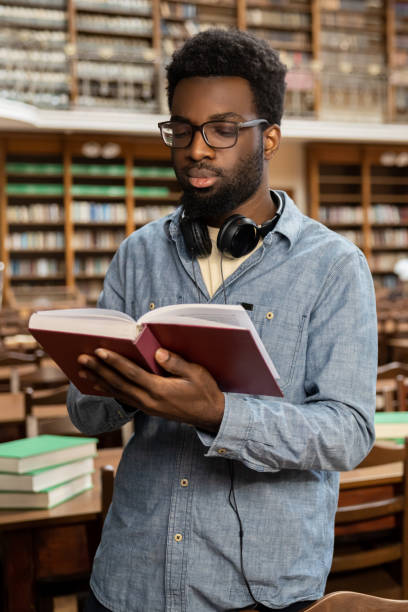 istock African american young man in the library looking busy and involved 2156494342