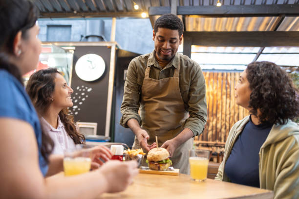 istock Man serving hamburgers to women 2156497429