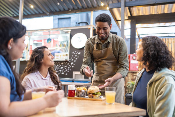 istock Man serving hamburgers to women 2156497451