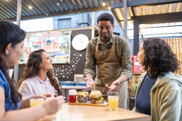 istock Man serving hamburgers to women 2156497452