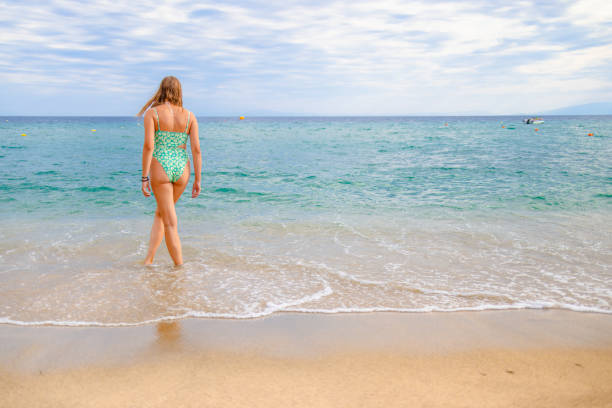 istock Young Caucasian woman playing with waves on the beach 2156500102
