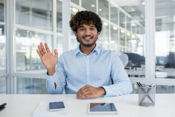 istock Friendly businessman waving during a video call in office 2156500667