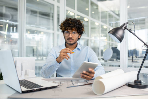 istock Architect working at a modern office with digital tablet and plans 2156500758