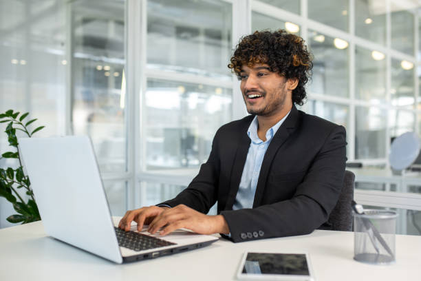 istock Young businessman working happily on laptop in modern office 2156500835