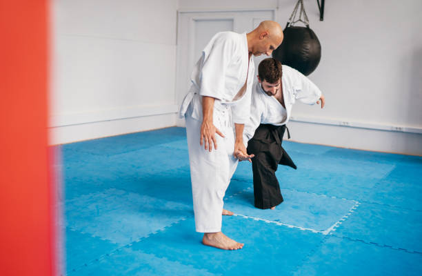 istock Two men are practicing Aikido in dojo wearing traditional white Kimono and Hakama .One man executes precise Kote-Gaeshi technique demonstrating control and skill in this martial art. 2156503970