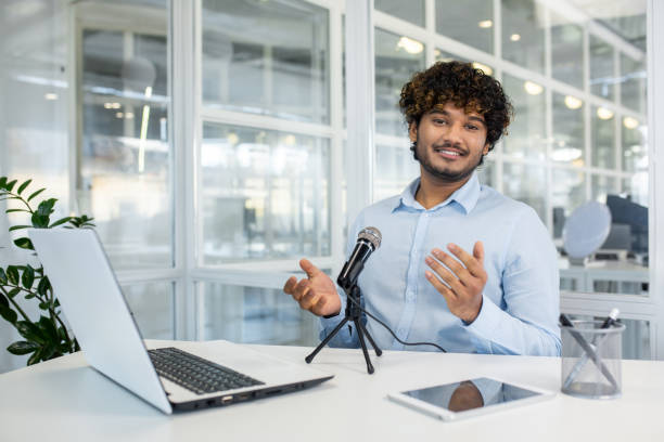 istock Young man recording a podcast in a modern office setting 2156504939