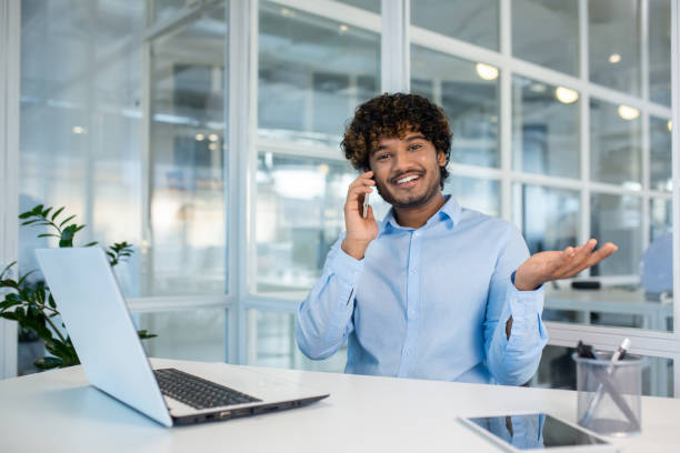 istock Smiling businessman talking on phone at modern office desk 2156505613